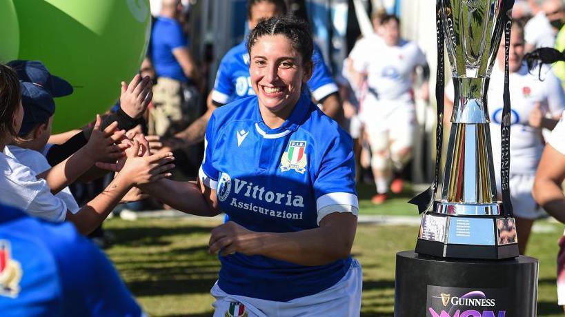 Silvia Turani, accanto al trofeo del Women's Six Nations (Sei Nazizoni Femminile), saluta un pubblico di giovani fan